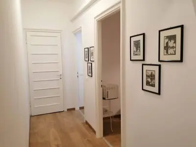a hallway with white walls and pictures on the wall at Art House Vatican Elegante appartamento Centrale in Rome