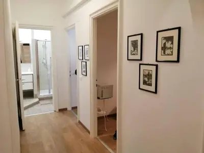 a hallway with a white wall with pictures on it at Art House Vatican Elegante appartamento Centrale in Rome