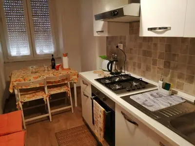 a kitchen with a stove top oven next to a table at Art House Vatican Elegante appartamento Centrale in Rome