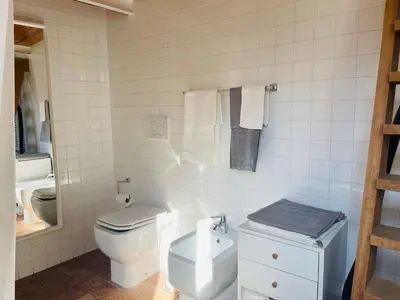 a white bathroom with a toilet and a sink at Silent Oasis of Trastevere in Rome