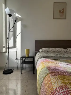 a bedroom with a bed and a lamp and a table at Metronio Relax in Rome