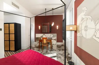 a bedroom with a fireplace and a pink rug at Alma at Colosseum Luxury Apartment with View in Rome