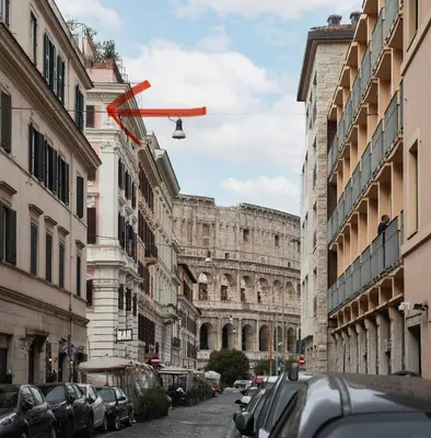 a plane flying over a city street with buildings at Alma at Colosseum Luxury Apartment with View in Rome