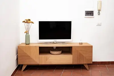 a tv on top of a wooden entertainment center at Domina Apartments Roma - San Pietro 3 in Rome