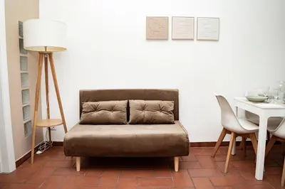 a living room with a chair and a table at Domina Apartments Roma - San Pietro 3 in Rome
