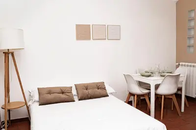 a bedroom with a bed and a table with chairs at Domina Apartments Roma - San Pietro 3 in Rome