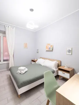 a bedroom with a bed and a green chair at Rome Vatican Stay - Appartamento 2 camere da letto vicino al Vaticano in Rome