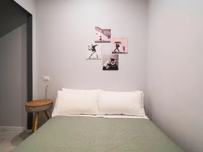 a bedroom with a bed with pictures on the wall at Rome Vatican Stay - Appartamento 2 camere da letto vicino al Vaticano in Rome