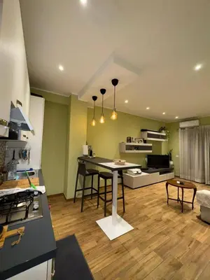 a kitchen and living room with a table and a couch at Nicoletti in Rome