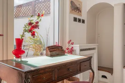 a room with a table with a red vase on it at La Terrazza Loft near San Pietro in Rome