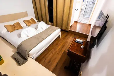 a bedroom with a bed and a table and a window at Domus Pellegrino heart of ROME in Rome