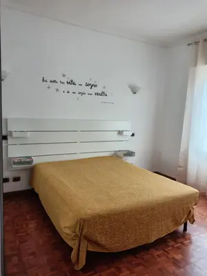 a bedroom with a bed with a writing on the wall at Mary Apartment in Rome