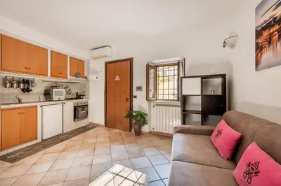 a living room with a couch and a kitchen at Vatican San Pietro - Giulia House in Rome