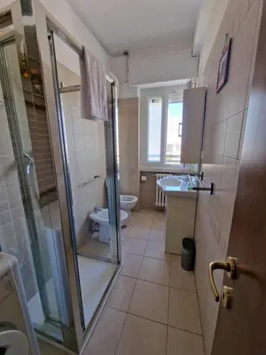 a kitchen with white cabinets and a counter in it at Casina Mori in Rome