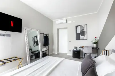 a white bedroom with a mirror and a bed at Hotelleria Prestige in Rome