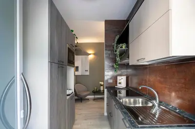 a kitchen with white cabinets and a sink at Hotelleria Prestige in Rome