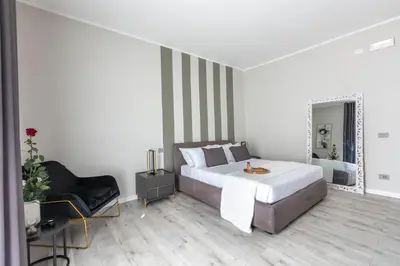 a bedroom with a bed and a chair and a mirror at Hotelleria Prestige in Rome