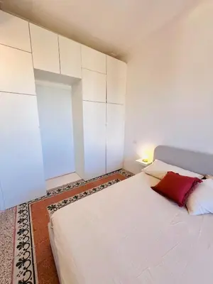 a bedroom with a white bed with a red pillow at Clarus apartment in Rome in Rome