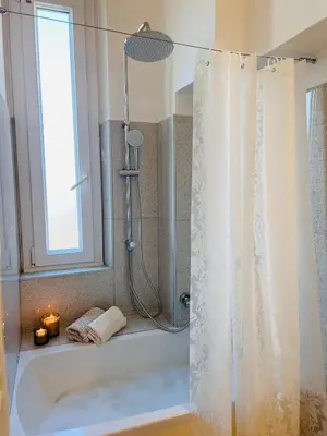 a bathroom with a shower and a tub with a window at Clarus apartment in Rome in Rome