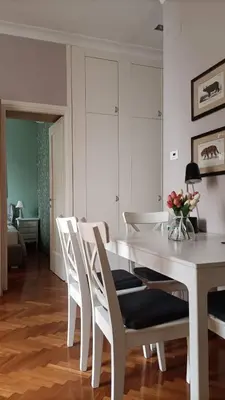 a white dining room with a white table and chairs at Colosseo Elegant Apartment in Rome