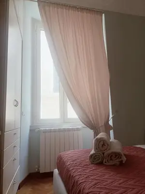 a bedroom with a bed with a curtain and towels at Colosseo Elegant Apartment in Rome