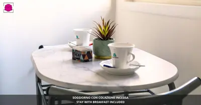a white table with two coffee cups and a plant at Desideri di Roma - Basilica San Paolo - Ospedale Bambin Gesu'-Roma III - 8th Piano Vicino la Metro in Rome