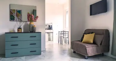 a bedroom with a dresser and a chair with a dresser and a tv at Desideri di Roma - Basilica San Paolo - Ospedale Bambin Gesu'-Roma III - 8th Piano Vicino la Metro in Rome