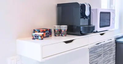 a counter with cups and a microwave and a coffee maker at Desideri di Roma - Basilica San Paolo - Ospedale Bambin Gesu'-Roma III - 8th Piano Vicino la Metro in Rome