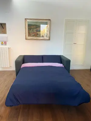 a blue bed in a room with a painting on the wall at Domus Quadraro II in Rome