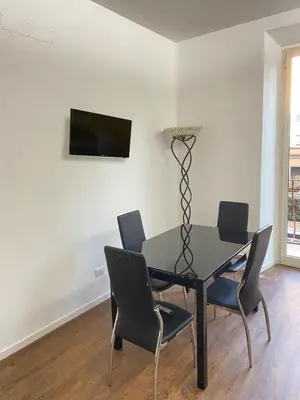 a dining room with a black table and chairs at Domus Quadraro II in Rome