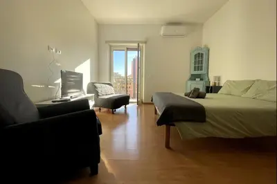 a bedroom with a bed and a couch and a chair at Bed Bike Breakfast Appartamento Piramide in Rome