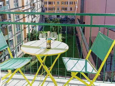 a table and chairs on a balcony with a bottle of wine at Bed Bike Breakfast Appartamento Piramide in Rome