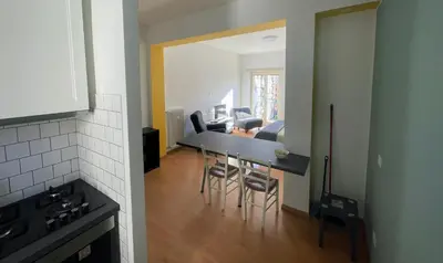 a kitchen and living room with a table and chairs at Bed Bike Breakfast Appartamento Piramide in Rome