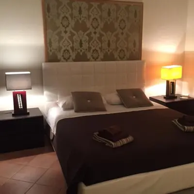 a bedroom with a large bed with two lamps on it at La Maison de Kappa in Rome
