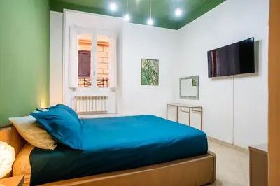 a bedroom with a blue bed and a flat screen tv at Apartment Maria in Monti in Rome
