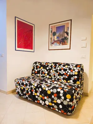 a couch sitting in a living room with paintings at Apartment Maria in Monti in Rome