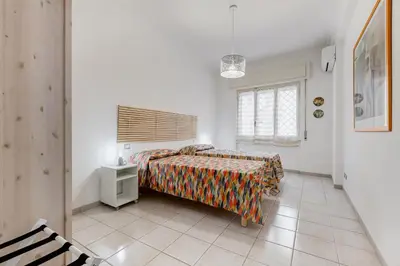 a white bedroom with a bed and a window at Cozy 2-Bedroom Flat with Balcony in Monteverde in Rome