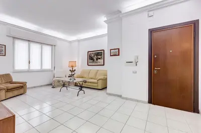 a living room with two couches and a wooden door at Cozy 2-Bedroom Flat with Balcony in Monteverde in Rome