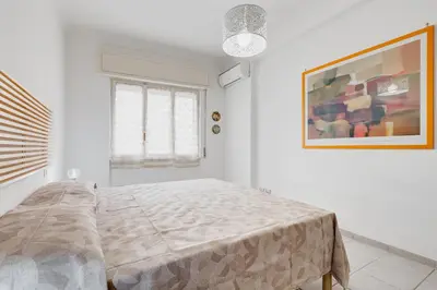 a bedroom with a bed and a painting on the wall at Cozy 2-Bedroom Flat with Balcony in Monteverde in Rome