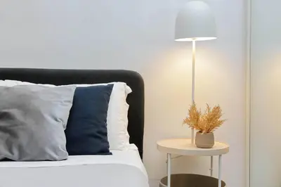 a bed with a blue pillow and a table with a lamp at Il Rifugio di Boezio by DomusDimore in Rome