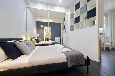 a bedroom with a large bed and a living room at Il Rifugio di Boezio by DomusDimore in Rome