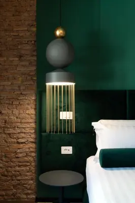 a bedroom with a green wall with a bed and a table at Colonna Collection in Rome