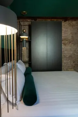 a bedroom with a large white bed with green pillows at Colonna Collection in Rome