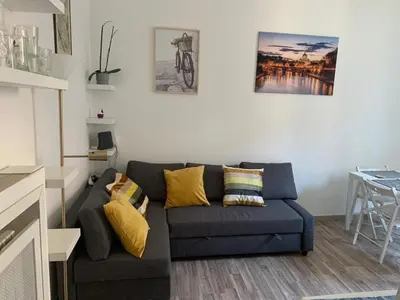 a living room with a blue couch with yellow pillows at Apartment in Testaccio in Rome