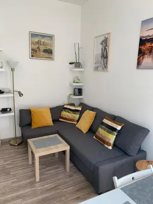 a living room with a blue couch and a table at Apartment in Testaccio in Rome