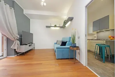 a living room with a blue couch and a kitchen at New Apartment with balcony - 150m Metro A in Rome
