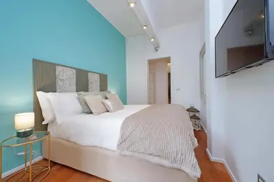 a bedroom with a large white bed with a flat screen tv at New Apartment with balcony - 150m Metro A in Rome