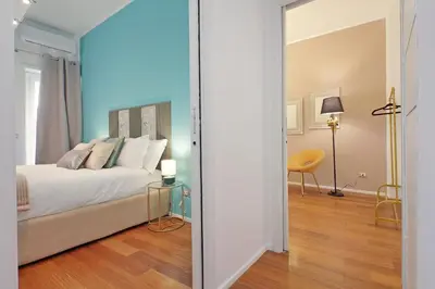 a bedroom with a bed and a table with a chair at New Apartment with balcony - 150m Metro A in Rome