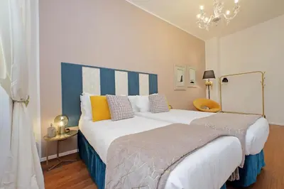 a bedroom with two beds and a chandelier at New Apartment with balcony - 150m Metro A in Rome
