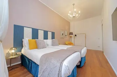 a hotel room with two beds and a chandelier at New Apartment with balcony - 150m Metro A in Rome